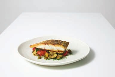 Pan-seared Daintree barramundi fillet with crispy skin on roasted vegetables