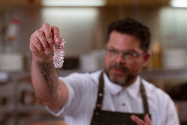 Chef Alejandro holding sashimi