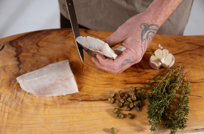 Slicing barramundi fillet